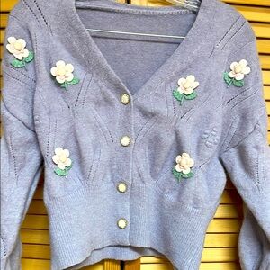 Pretty sweater with flowers and sparkling buttons.